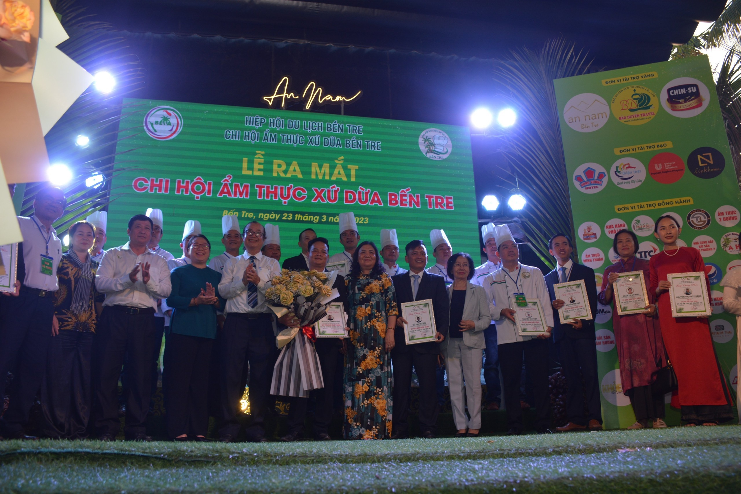 Chủ tịch HĐND tỉnh Bến Tre Hồ Thị Hoàng Yến (áo dài, giữa) trao hoa chúc mừng các thành viên Chi hội Ẩm thực Bến Tre - Ảnh: Trần Lợi